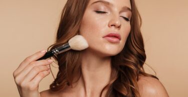 Beauty portrait sensual ginger woman with long hair closed eyes applying cosmetics with brush 171337 940